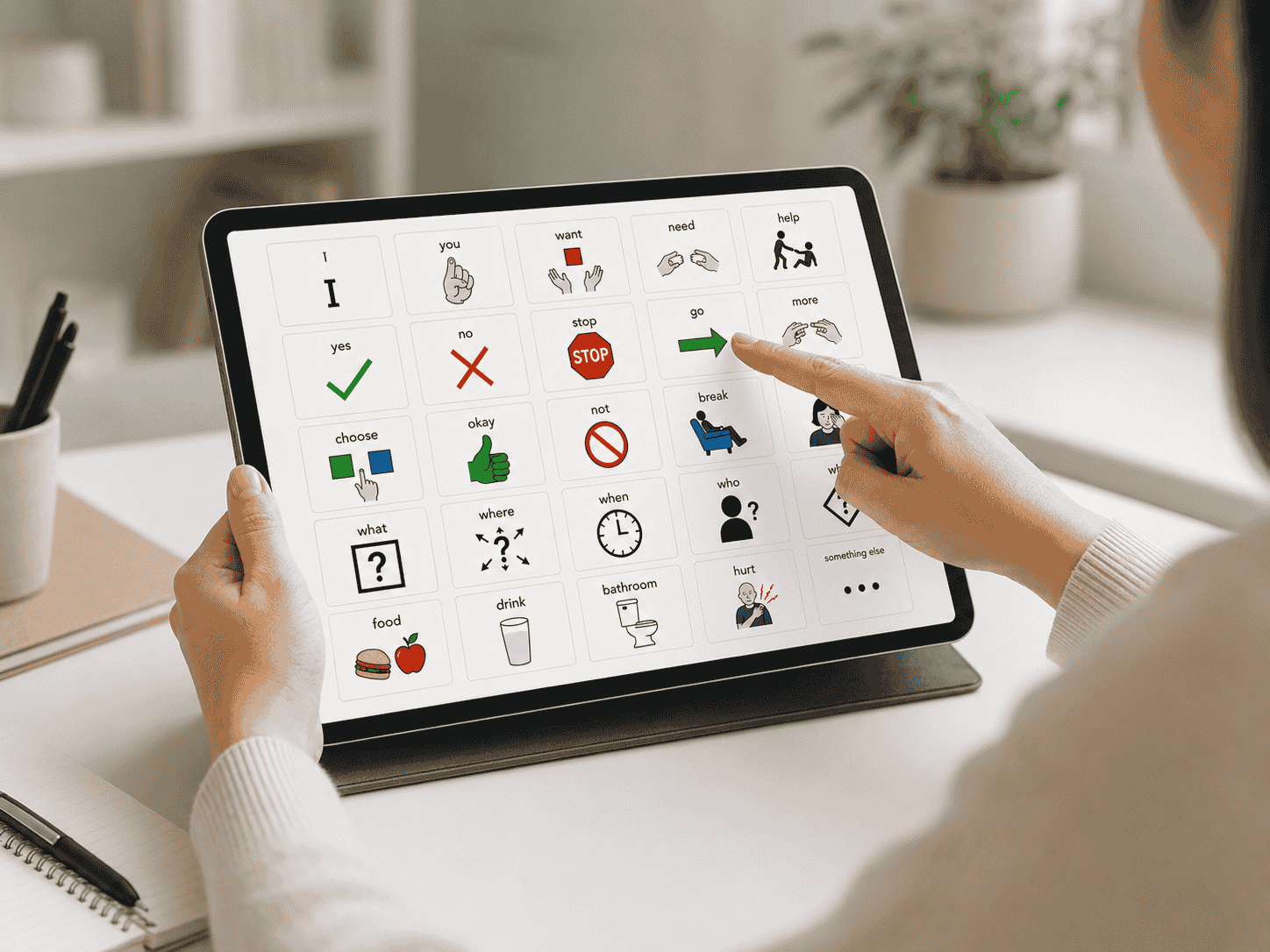 AAC visual communication board displayed on a desktop screen with icons for words like I, you, want, need, and help